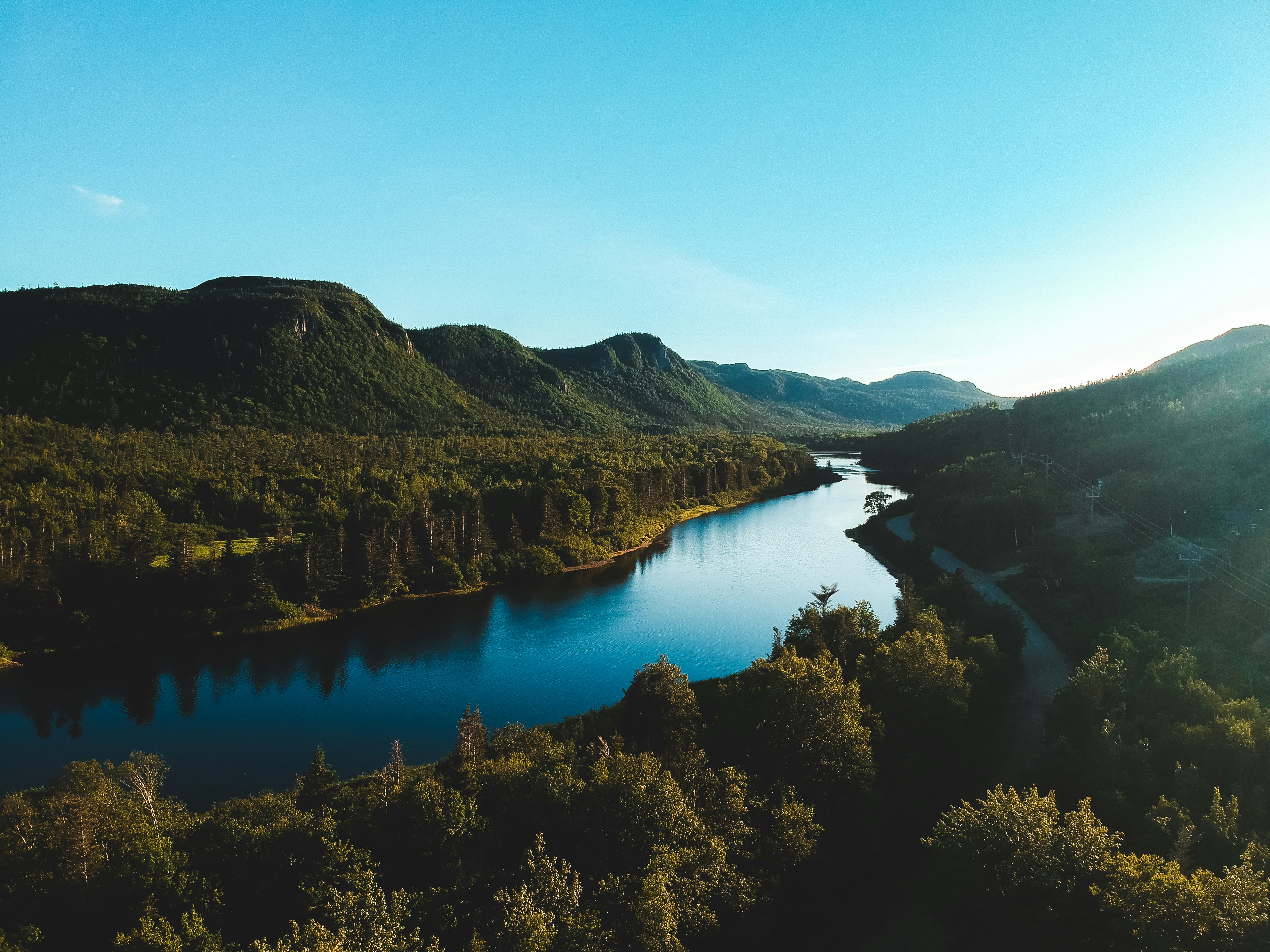 lake surrounded by trees and mountains during daytime